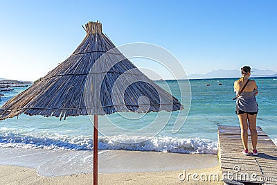 woman watching the Adriatic Sea in the crystal clear bathing area of â€‹â€‹Bora Bora beach in Ksamil, Albania. Stock Photo